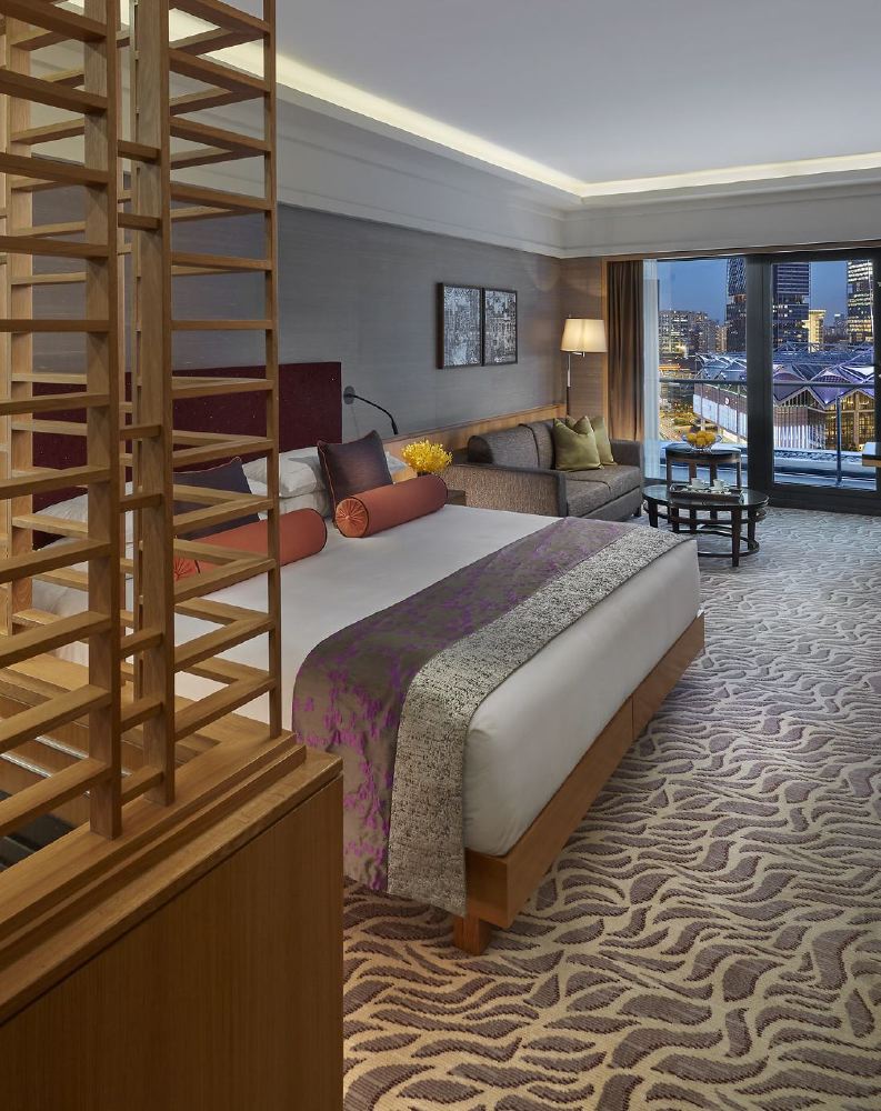 Luxurious hotel room at Mandarin Oriental, Singapore, featuring sophisticated décor and a city view, ideal for visitors to the Singapore Grand Prix and those seeking premier accommodations in Singapore.