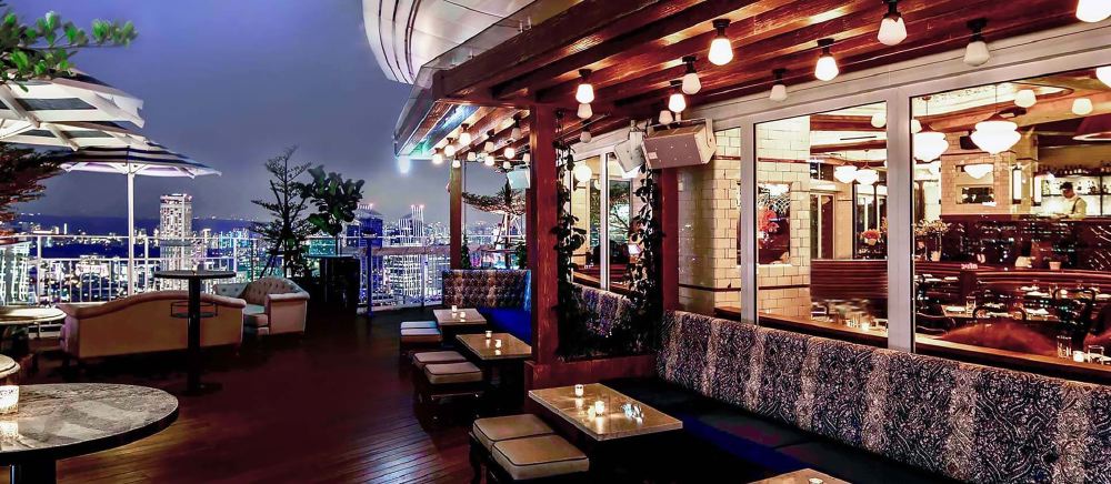 Outdoor dining terrace at LAVO Italian Restaurant atop Marina Bay Sands in Singapore, offering a panoramic view of the city's skyline, ideal for guests seeking luxury accommodations near the Singapore Grand Prix.