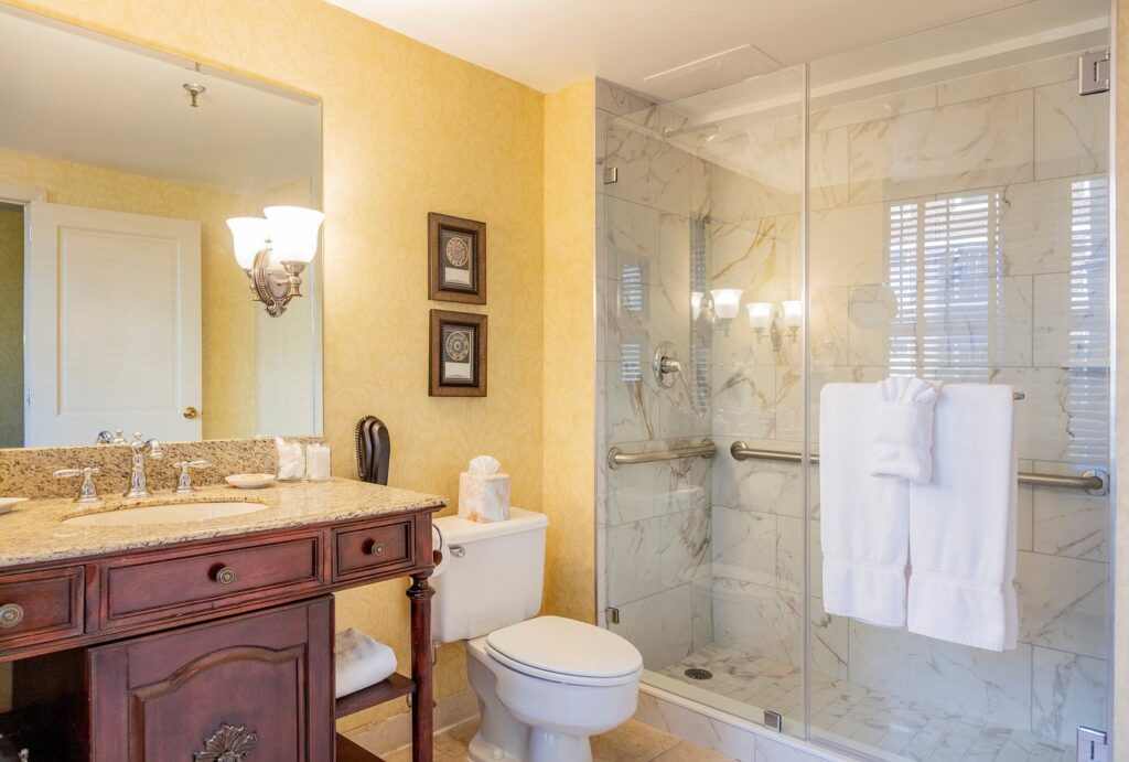 Elegant bathroom at The Brown Hotel in Louisville, featuring marble shower, granite countertop, and classic furniture, ideal for guests visiting for the Kentucky Derby.