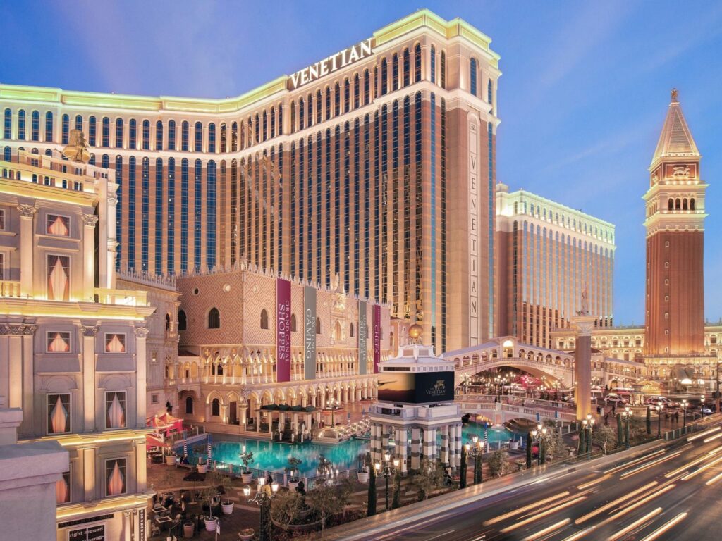 Brightly lit Venetian Resort on Las Vegas Boulevard, showcasing its Grand Canal Shoppes and iconic replicas of Venetian landmarks, an ideal location for Las Vegas Grand Prix accommodations.