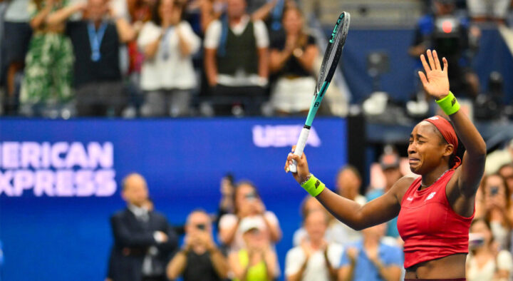 A female tennis player celebrates a victory at a US Open Tennis match, surrounded by cheering spectators, promoting the excitement of the US Open Tennis Getaway Rates.