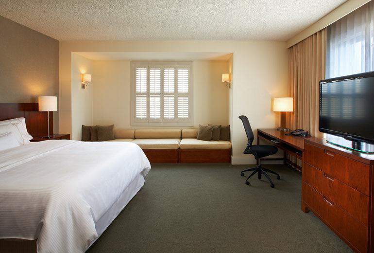Spacious room at the Westin Pasadena with a king-sized bed, a dedicated workspace, and a cozy sitting area, located near venues for the Rose Bowl in Pasadena, California.