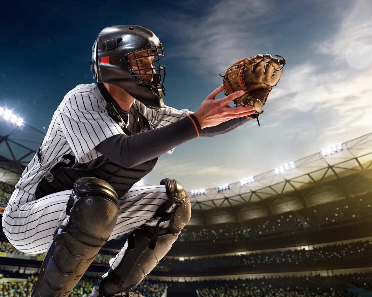 A baseball catcher in striped uniform is crouched, glove out, ready to catch a pitch in a stadium, ideal for those looking into baseball travel and ticket packages.
