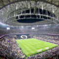 Wide-angle view of a packed stadium during a World Cup soccer match, featuring a large crowd and a closed retractable roof, in USA, Mexico, or Canada.