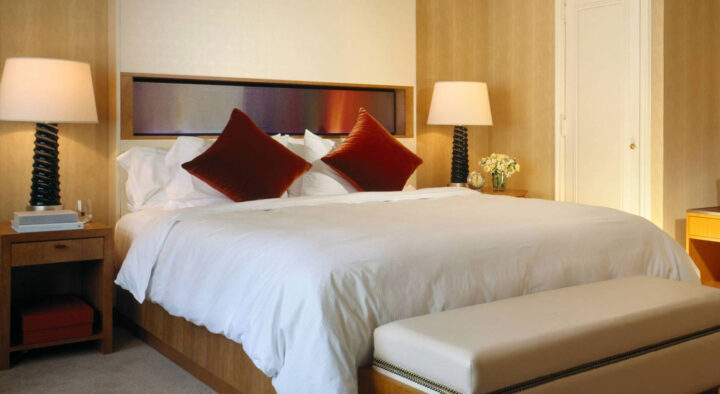 Luxury hotel room with a large bed, crisp white bedding, and elegant lamps, ideal for World Series accommodations.