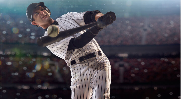 Baseball player in striped uniform swinging bat in a well-lit stadium, perfect for exploring Baseball Travel and Hotel Ticket Packages.