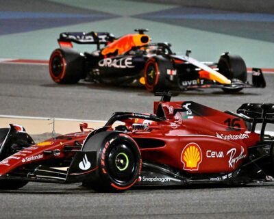 Two Formula 1 cars race closely on a track, one from team Ferrari and another from team Red Bull, showcasing high-speed competition typical of events like the Canadian Grand Prix.