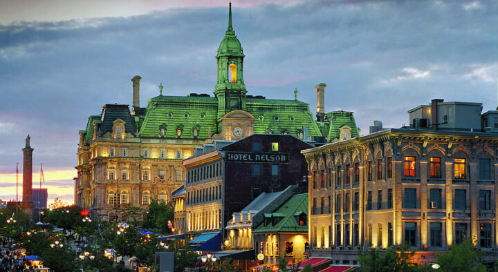 A vibrant evening view of Montreal showcasing historic architecture and bustling streets, relevant for visitors exploring the city during the Canadian Grand Prix.