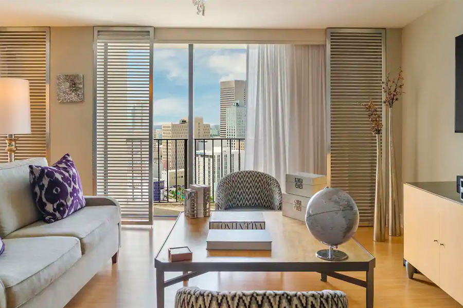 Modern hotel room featuring stylish decor with a large window that offers a panoramic view of the Miami skyline, ideal for guests attending the Miami Grand Prix.
