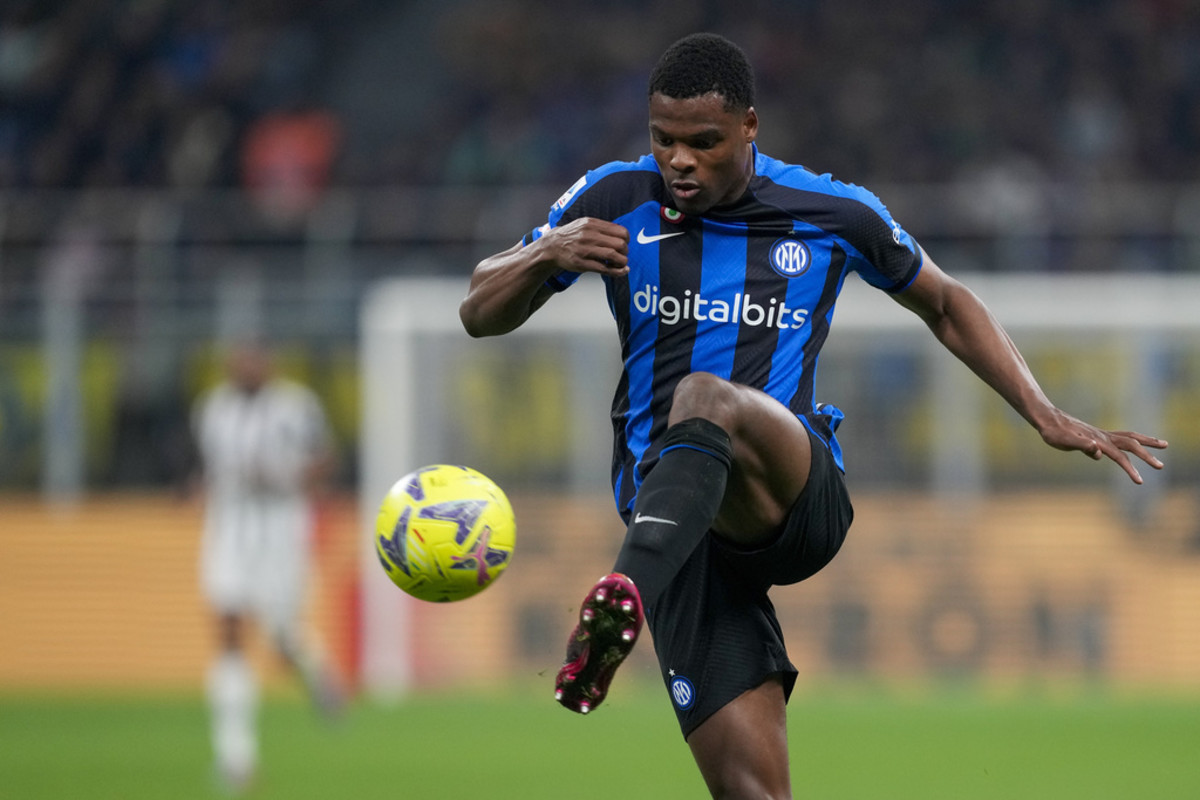 A soccer player in a blue and black striped jersey controls the ball during a match, illustrating the dynamic action typical at the Champions League Final events.