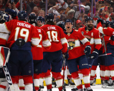 Florida Panthers players celebrate enthusiastically on the ice during a hockey game, likely relating to a significant event or victory.