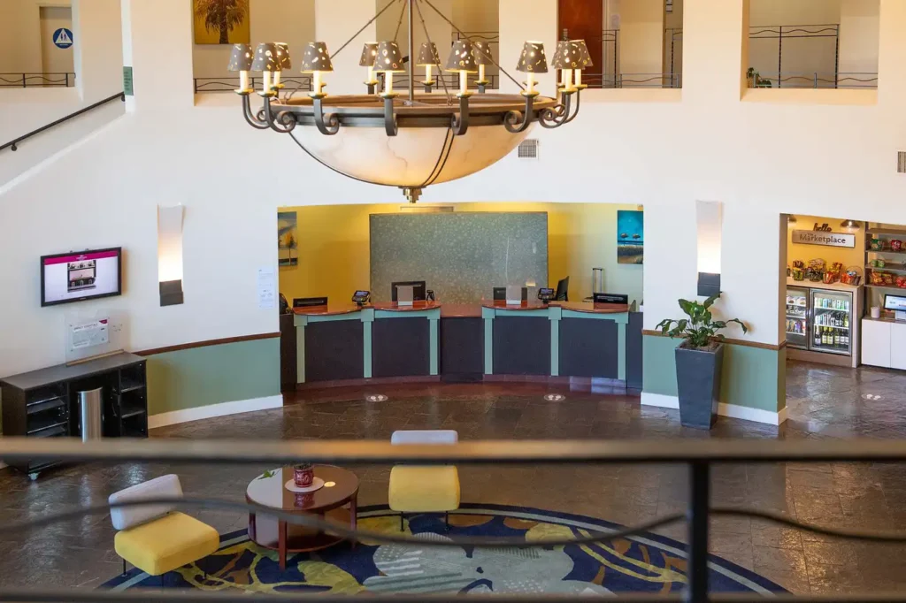 View of the spacious lobby in Cabana Hotel Palo Alto featuring a reception desk, chandelier, and a snack area, ideal for Super Bowl accommodations in the South Bay Area.