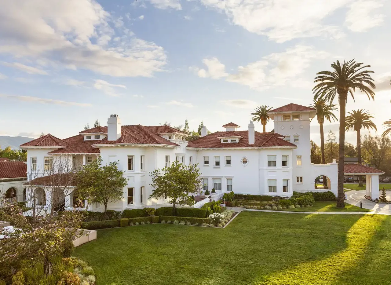 Elegant mansion surrounded by manicured gardens and tall palm trees, ideal for travelers seeking luxury accommodations near the stadium for Super Bowl events.
