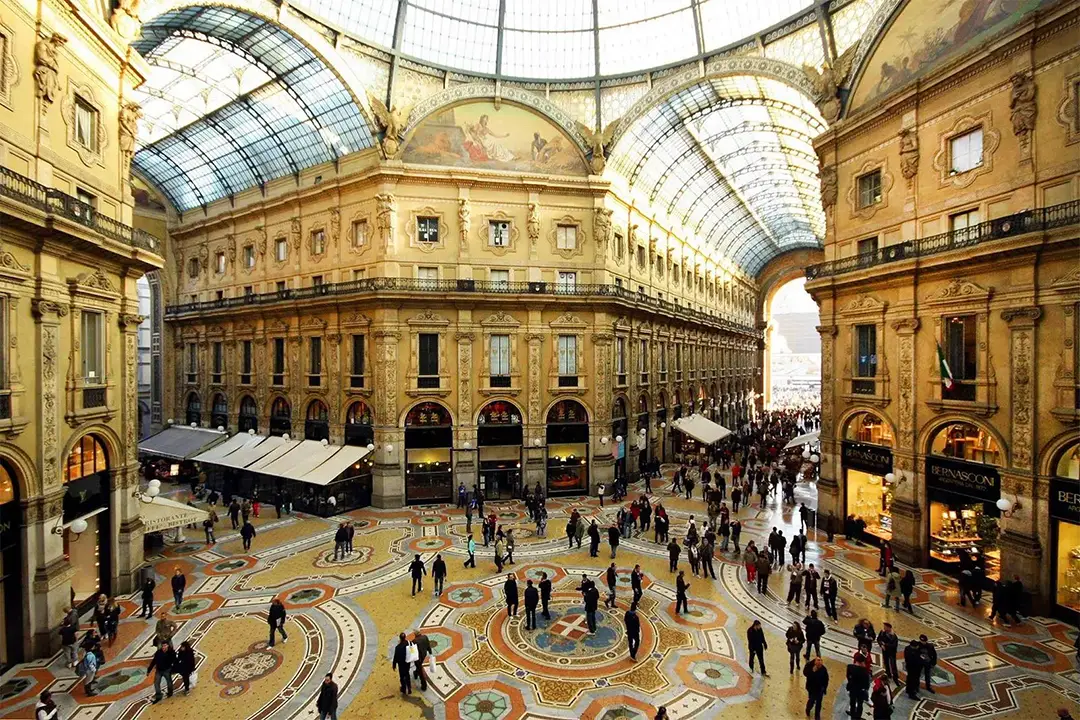 Crowded shoppers explore the opulent Galleria Vittorio Emanuele II in Milan, a renowned destination for its luxury shopping and distinctive architecture, perfect for Milan Food Adventures and Winter Games Add-Ons.
