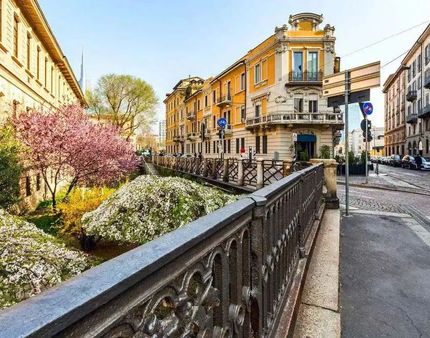 Lush spring blooms line a waterway near Pinacoteca Di Brera, enhancing Milan's vibrant Art District.